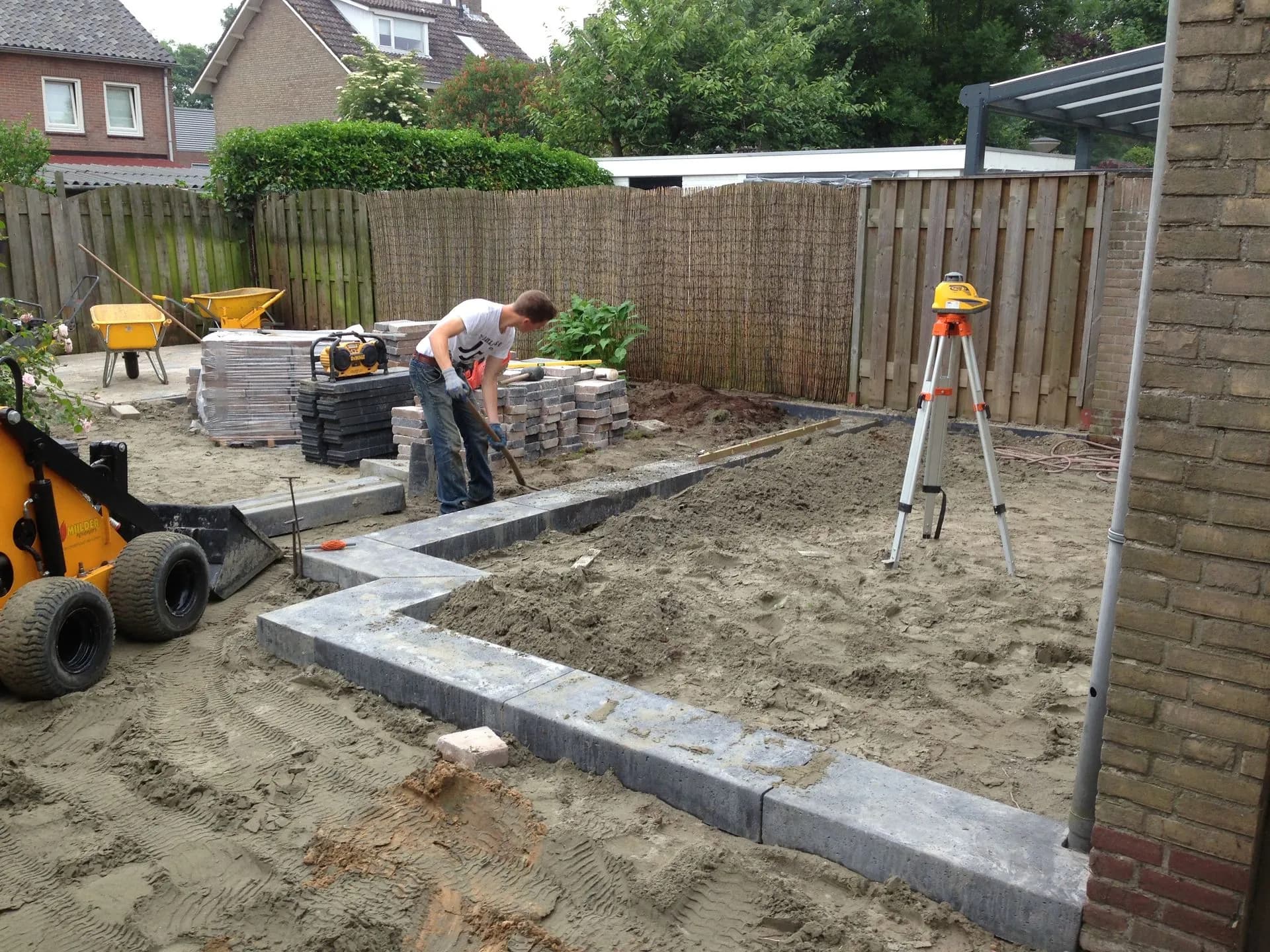 Aanleg van bestrating en borders in een tuin